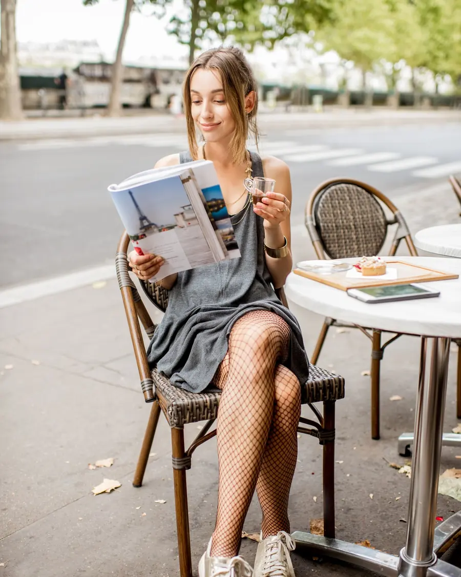 Mulher lendo uma revista em um café ao ar livre em Paris